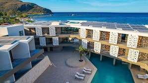 Un hôtel moderne doté d’une piscine sur le toit, de panneaux solaires et offrant une vue sur l’océan.