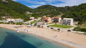 Una zona costera con playa, varios edificios y barcos.