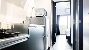 A modern kitchen with stainless steel appliances, a coffee machine, and a microwave. - Villa Awase 111 (Okinawa)