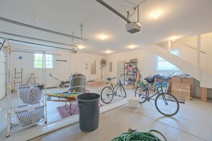 Una habitación amplia con un espejo grande, una bicicleta y un proyector montado en el techo.