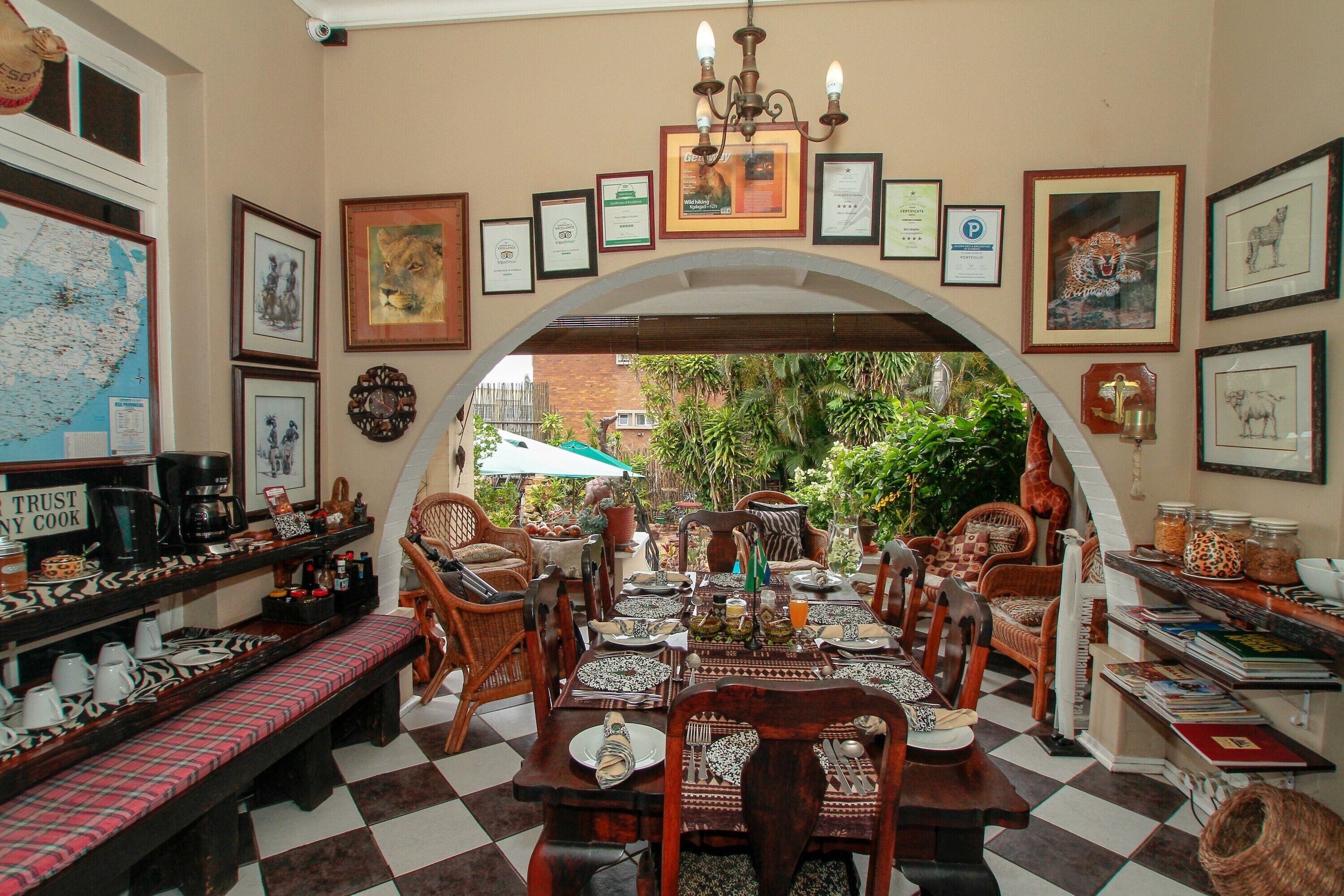 A dining area with a checkered floor, wooden furniture, and framed pictures on the walls.