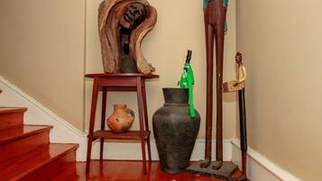 A staircase with wooden steps, a vase, a wooden sculpture, and a green umbrella.