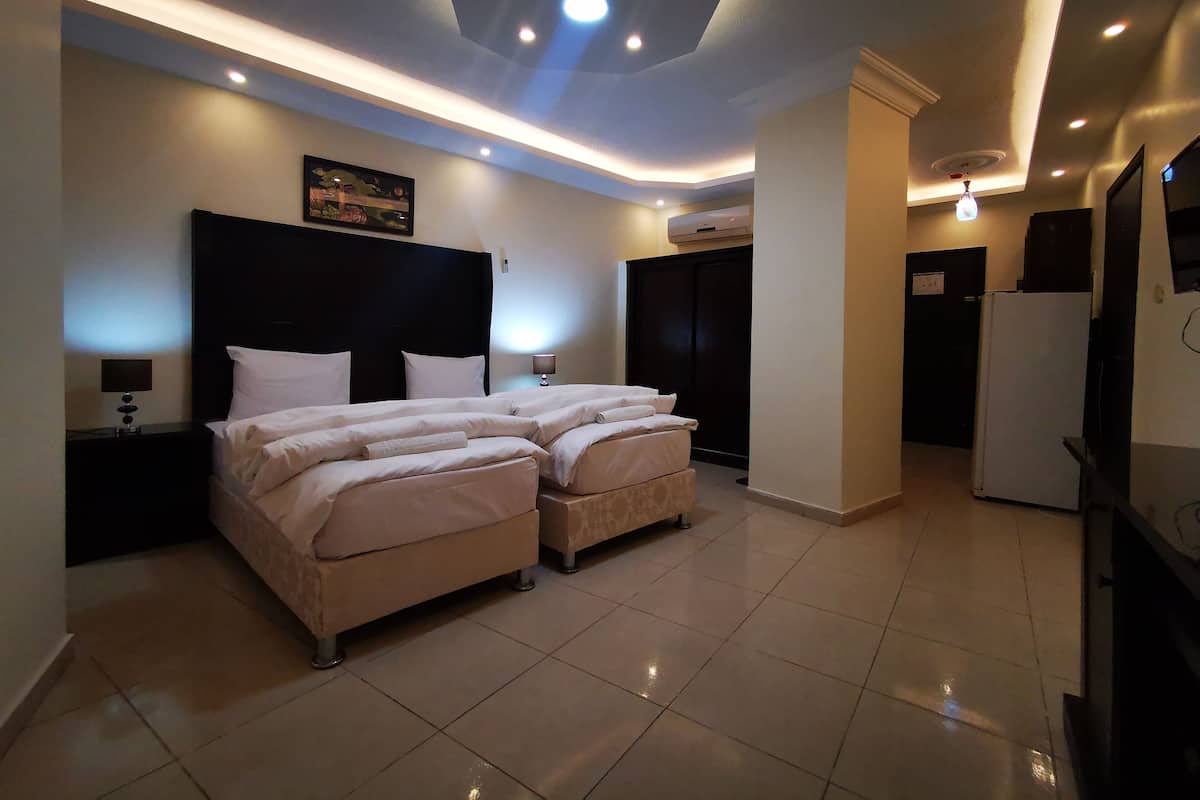 A modern hotel room with a large bed, a flat-screen TV, and a ceiling with recessed lighting.