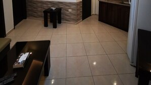 Una cocina moderna con refrigerador empotrado, armarios de madera oscura y piso de baldosas.