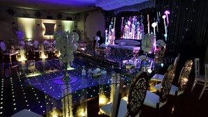 Un comedor lujoso con una mesa de vidrio, sillas elegantes e iluminación ambiental.
