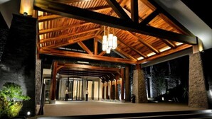 A spacious lobby with a high ceiling and wooden beams, a large chandelier, and a stone pillar. - Hongzhushan Hotels and Resorts Chanyi Shanju (Leshan)