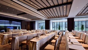 A conference room with long tables, chairs, and a large window providing a view of the outdoors. - Hongzhushan Hotels and Resorts Chanyi Shanju (Leshan)