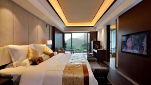 A modern hotel room with a large bed, a TV, and a view of the outdoors. - Hongzhushan Hotels and Resorts Chanyi Shanju (Leshan)