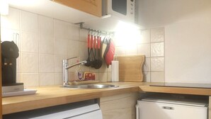 A kitchen with a dishwasher, a refrigerator, a sink, and a microwave.