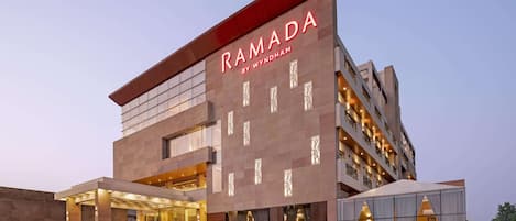 Un edificio moderno con el nombre 'RAMADA BY WYNDHAM' claramente visible.