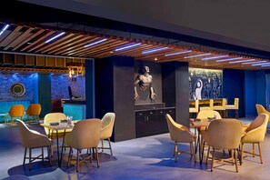 Un interior moderno con una zona de bar, asientos y una escultura.