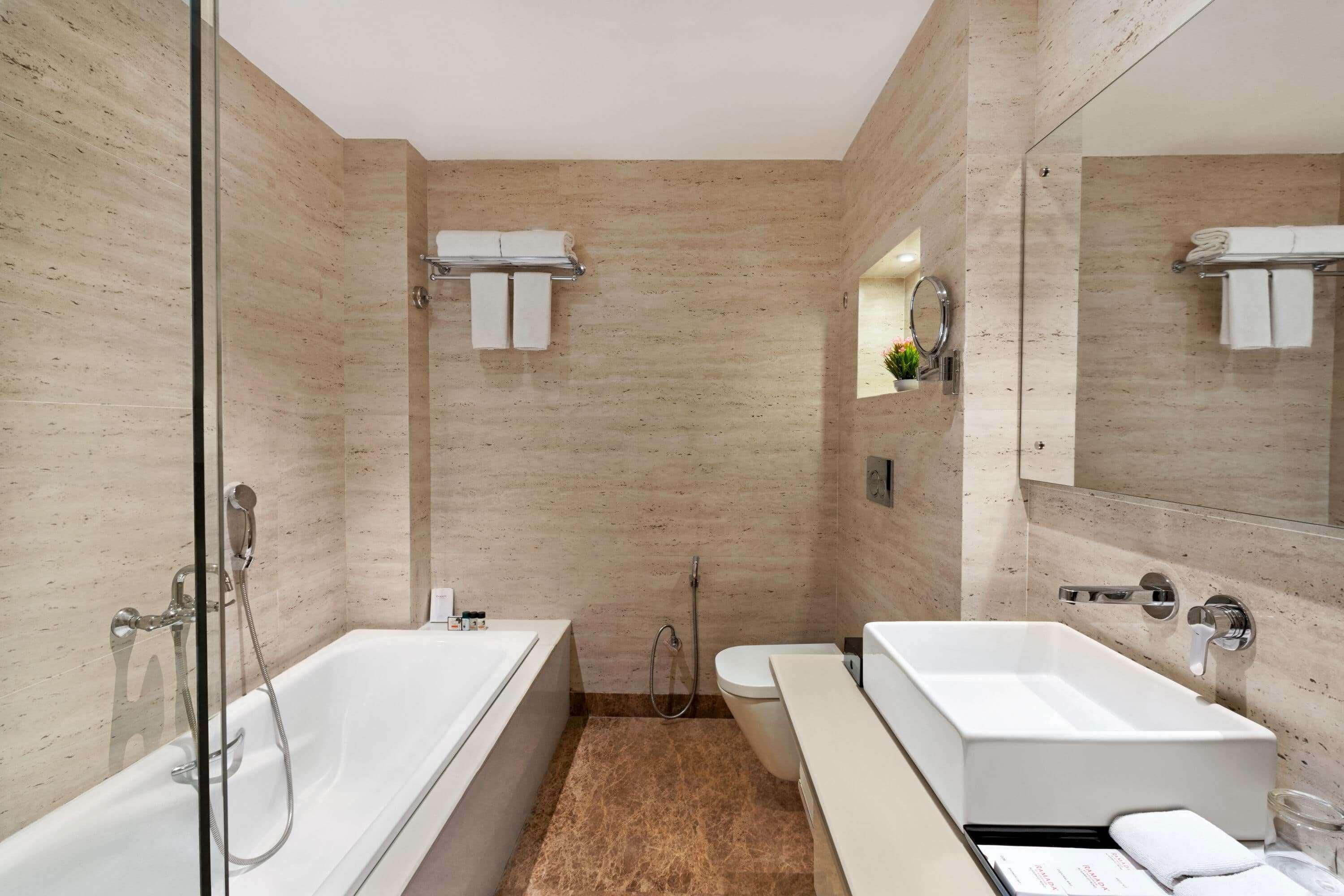 A modern bathroom with a glass-enclosed shower, a separate toilet, and a vanity with a mirror.