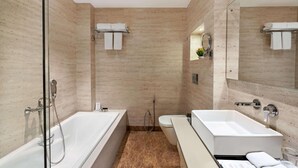 A modern bathroom with a glass-enclosed shower, a separate toilet, and a vanity with a mirror.