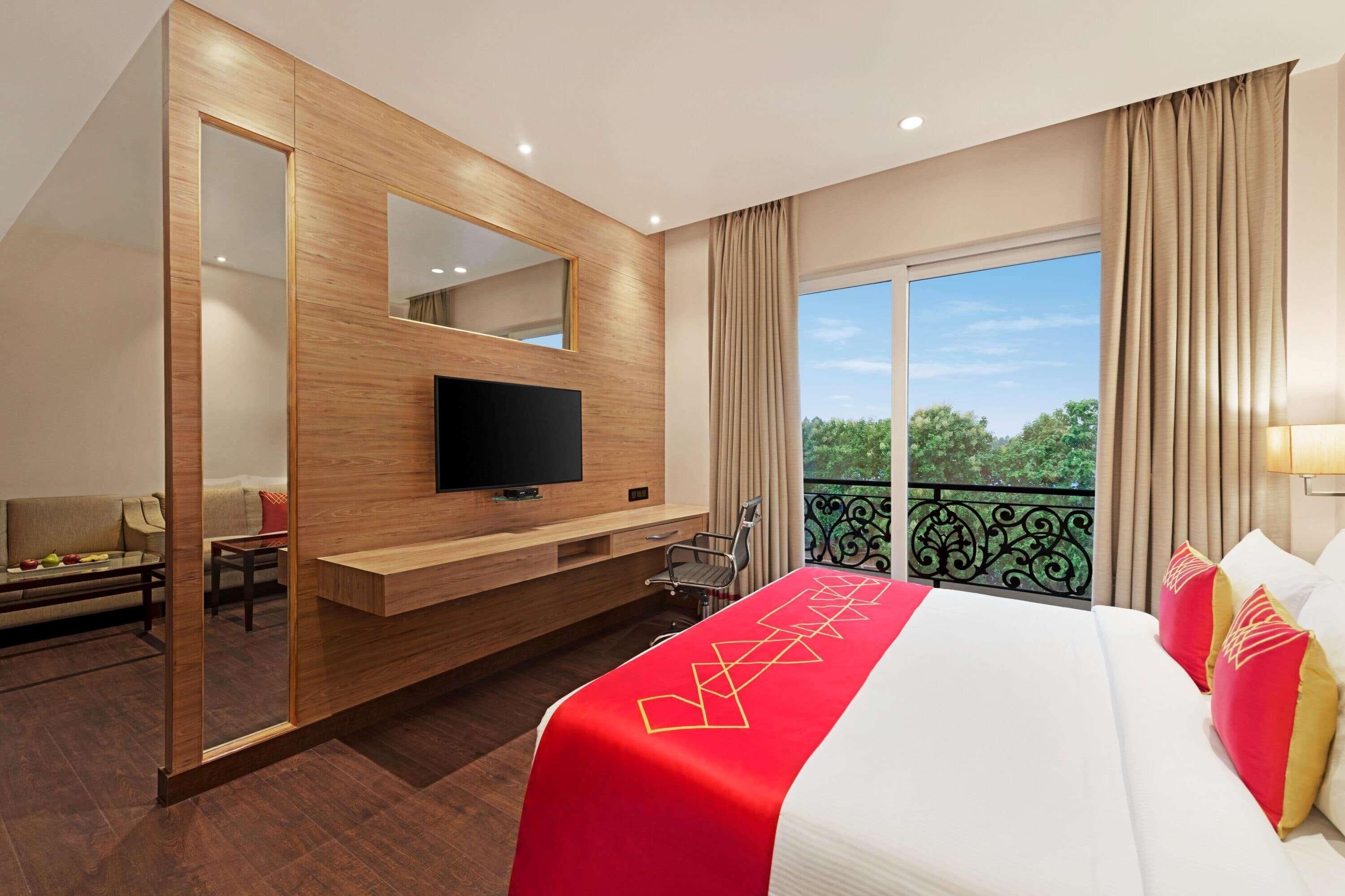 Une chambre d’hôtel avec un lit, une télévision, un balcon avec vue et un mur en bois.