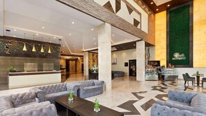 A spacious lobby with a reception desk, seating area, and a coffee bar.