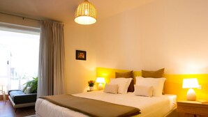 Camera d'albergo con un letto grande, lampade ai comodini, vista sull'esterno e una finestra con tende.