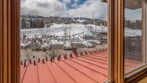 Een uitzicht op een besneeuwde piste met een stad op de achtergrond.