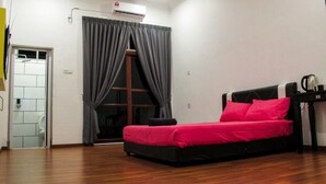 A room with a bed, a window with curtains, a door, and a small table with a kettle. - Multaqa Suite & Residence (Marang)
