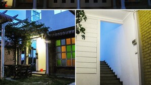 A two-story building with a traditional architectural style, featuring a central entrance with a covered porch and a staircase leading to the upper floor. - Multaqa Suite & Residence (Marang)