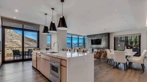 A modern kitchen with a central island, stainless steel appliances, and pendant lighting. - One Snowmass West 303 (SNOWMASS VILLAGE)
