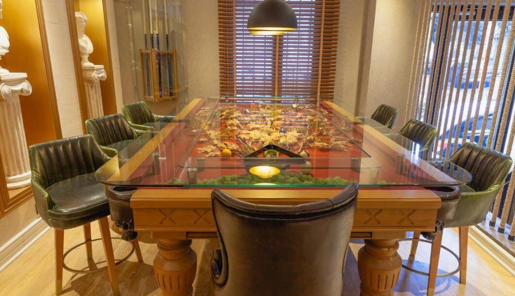 Un salón de conferencias con una mesa de vidrio, sillas de cuero y una decoración central.