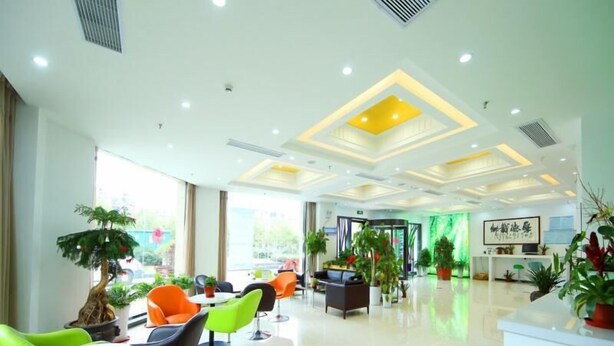 A modern hotel lobby with a reception desk, seating area with chairs, and potted plants. - Vaticawuxi Huishan District Western Shengan Road Baile Square Hotel (Wuxi)