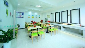 A bright, modern dining area with green chairs and tables, a long counter with a display, and ceiling lights. - Vaticawuxi Huishan District Western Shengan Road Baile Square Hotel (Wuxi)