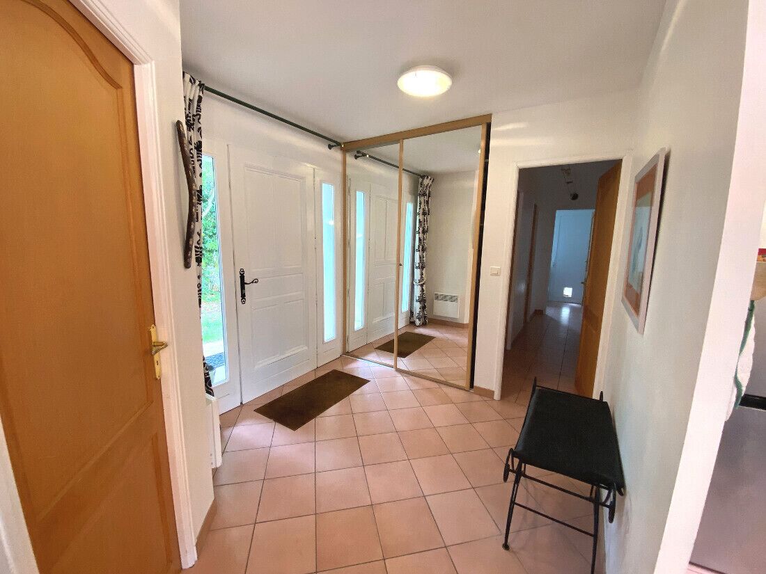 A hallway with white doors, a black folding table, and a tiled floor.