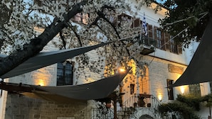 Un patio al aire libre con paredes de piedra, una chimenea de ladrillo y mobiliario exterior.