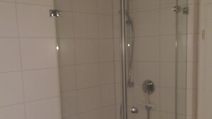 Une salle de bain dotée d’une douche à parois de verre et d’une baignoire îlot.