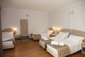 A hotel room with four beds arranged in a U-shape, a wardrobe, and bedside lamps. - Nebrodi Rooms Monte San Giovanni (San Marco d'Alunzio)