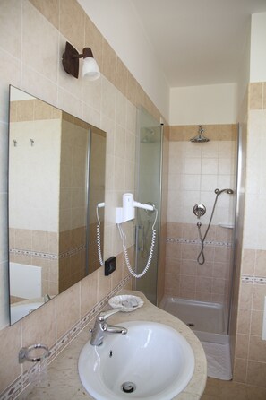 A bathroom with a sink, mirror, and shower. - Nebrodi Rooms Monte San Giovanni (San Marco d'Alunzio)