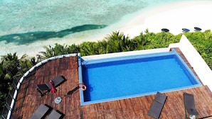 A rooftop pool with clear blue water, surrounded by a wooden deck and palm trees, overlooking a beach and ocean. - Ranthari Hotel and Spa Ukulhas Maldives (Ukulhas)