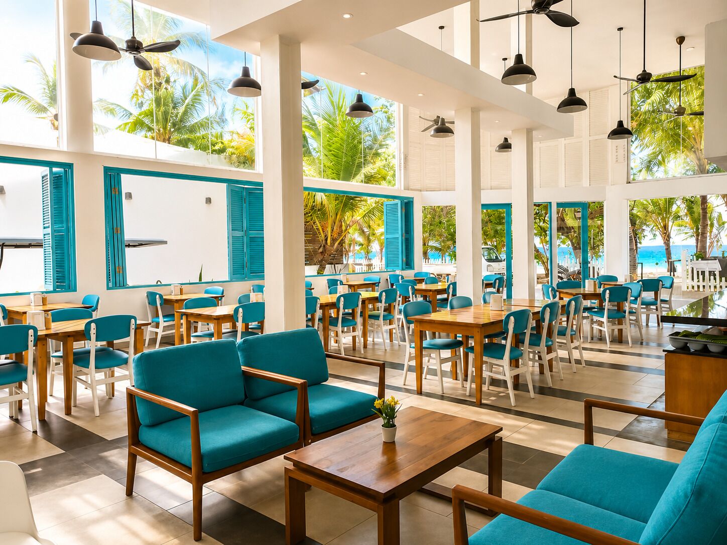 A spacious indoor area with tables and chairs, large windows with blue shutters, and a view of palm trees and the ocean.