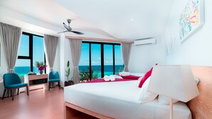 A modern hotel room with a large bed, a desk, two chairs, a ceiling fan, and a view of the ocean. - Ranthari Hotel and Spa Ukulhas Maldives (Ukulhas)