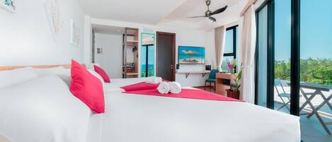 Une chambre d’hôtel avec un grand lit, un bureau, une chaise et un balcon avec vue.