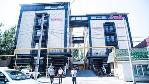 A hotel with a modern design, featuring a prominent entrance and multiple levels. - Turan Hotel (Almaty)