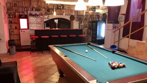 A pool table in a bar area with a bar counter and stools. - Former Pub 3 for Stag do  men's cave  bachelor, bachelorette party for sleepers (IX. kerület)