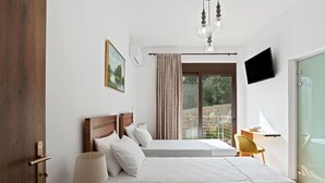 Un dormitorio con dos camas, una puerta de madera, una mesita de noche con una lámpara, un televisor y una ventana con cortinas.