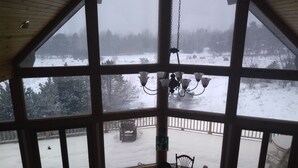 Ett rum med stora fönster som vetter ut mot ett snötäckt landskap.