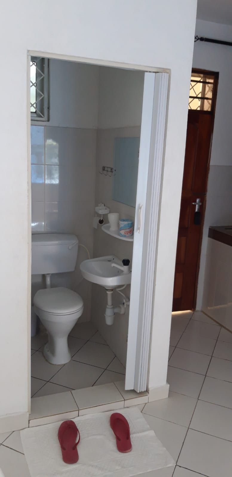 A small bathroom with a toilet, sink, and mirror.