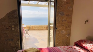 A bedroom with a bed, a window, and a view of the sea. - Villa Luciana 'Fantastic sunsets by the pool' (Lagkada)