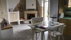 A cozy kitchen with a fireplace, wooden cabinets, and a dining area with chairs and a table. - Villa Luciana 'Fantastic sunsets by the pool' (Lagkada)