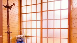 Una habitación japonesa tradicional con suelo de tatami, una puerta corredera de shoji y un banco de madera.