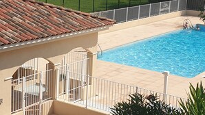 A swimming pool with a tiled deck, surrounded by a white fence and lush greenery. - Duplex apartment 6 people Cannes Grand Parc (Cannes)