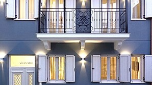 A building with a balcony, multiple windows with shutters, and a sign that reads "VILIELMINI Luxury Accommodation". - Villa Vilielmini (Ioannina)