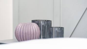 Three vases on a table against a white wall.