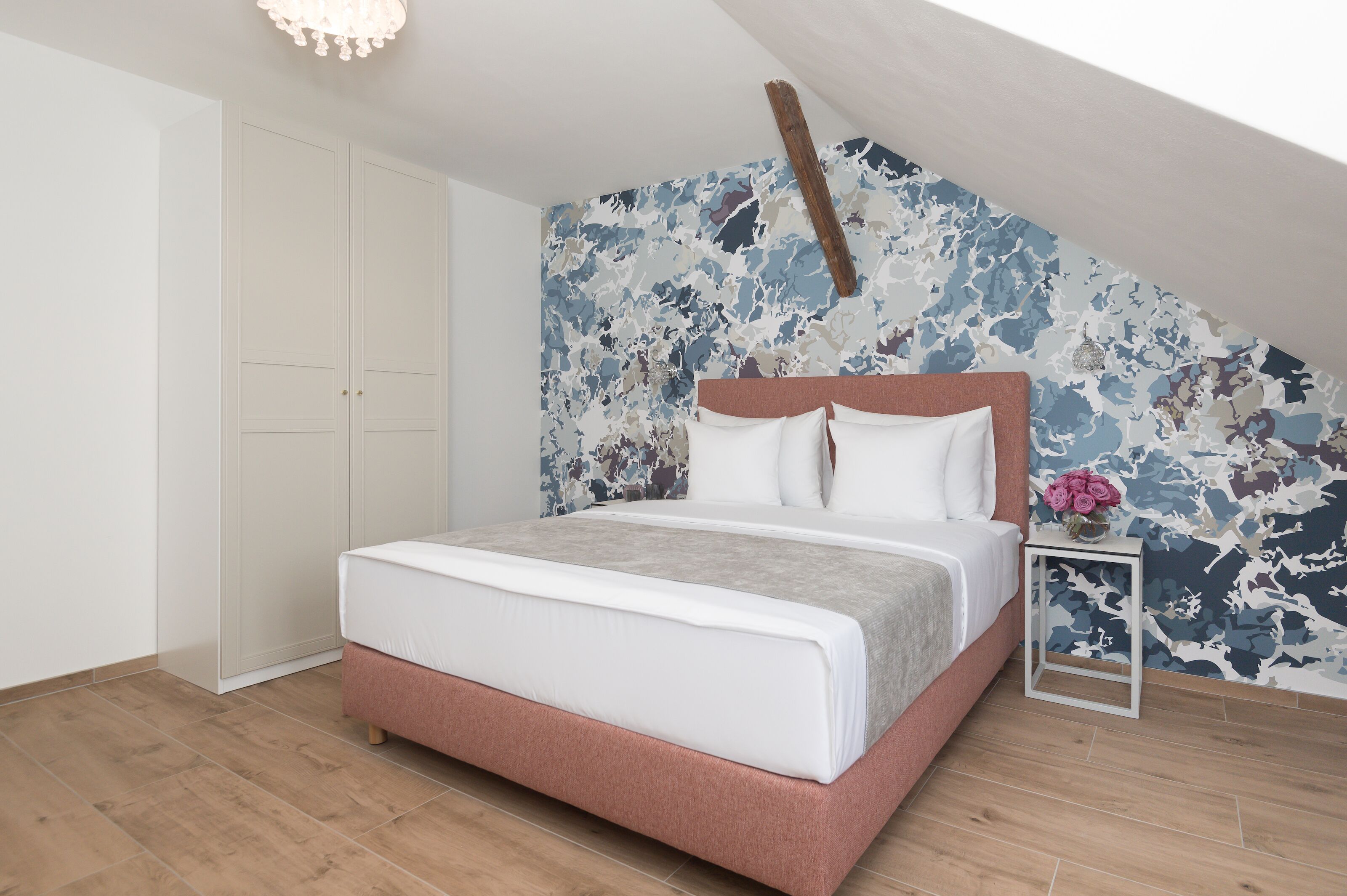 Ein Schlafzimmer mit einem Bett, einem weißen Wandschrank und einer Wand mit einem Tarnmuster.