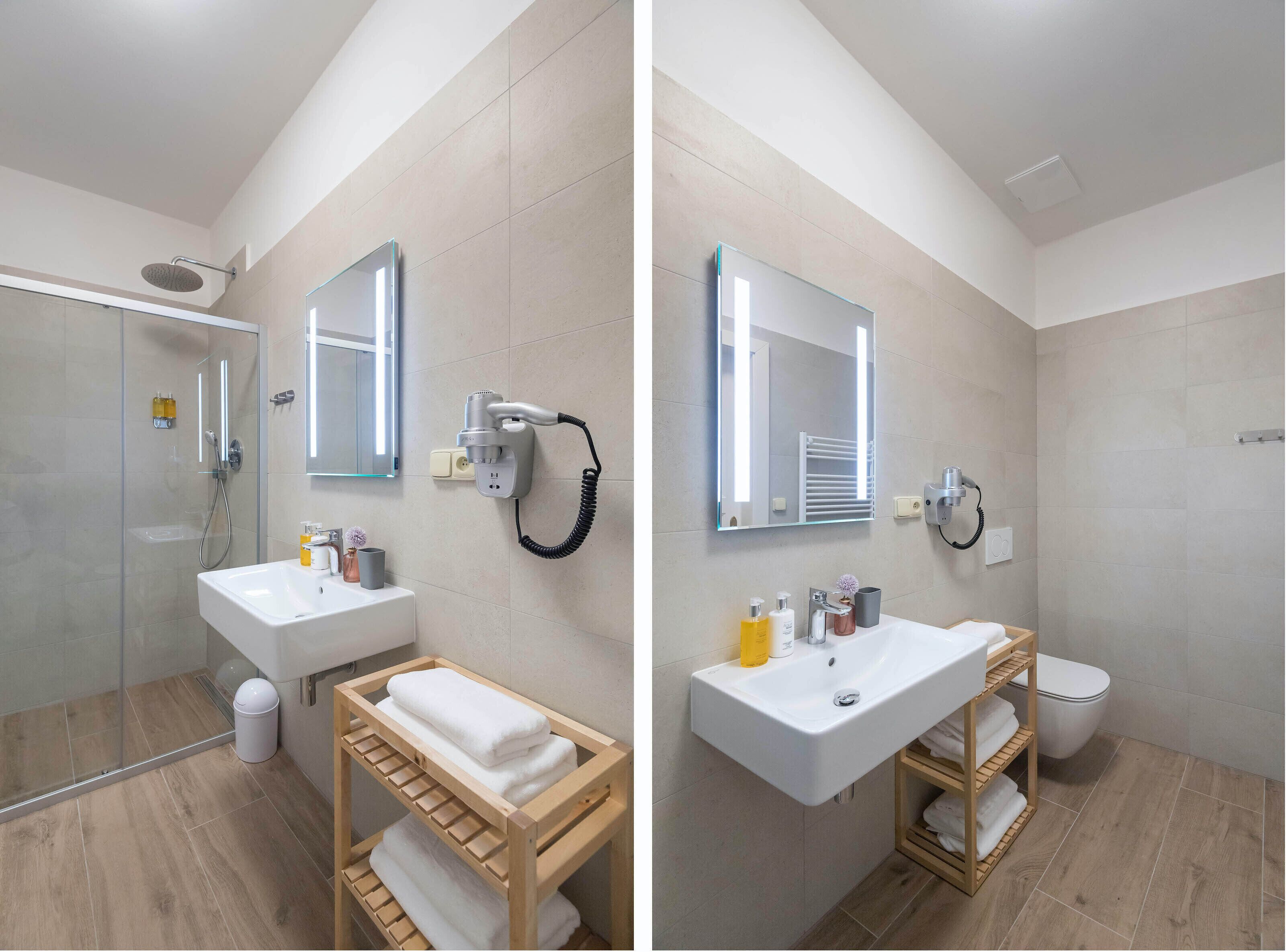 A modern bathroom with a glass shower enclosure, a white sink, a mirror, and a towel rack.