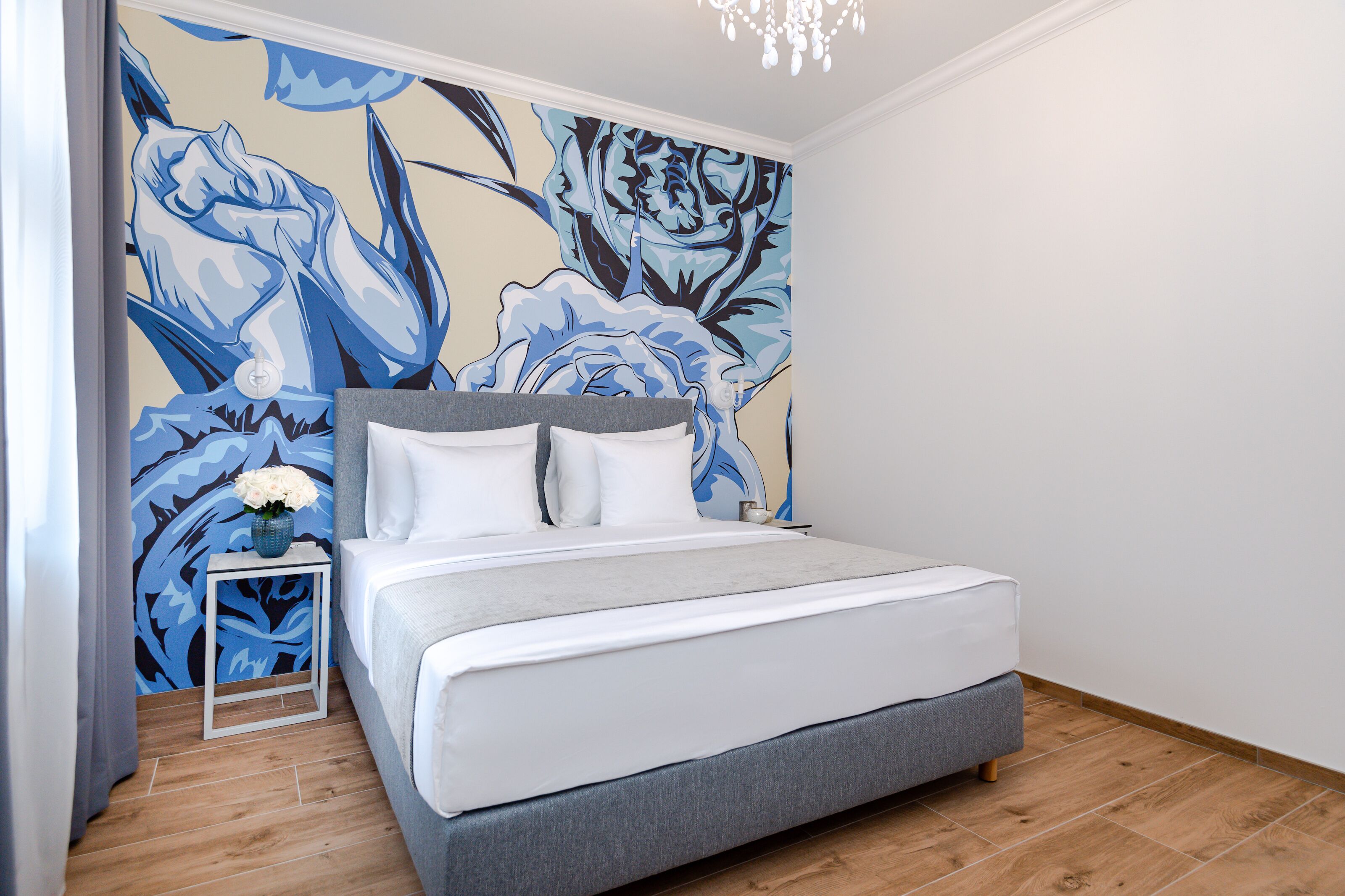 Una camera da letto con un letto, un comodino e un affresco.